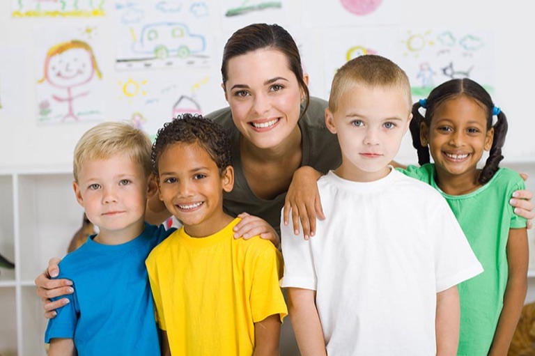Erzieherin mit vier Kindern im Gruppenraum