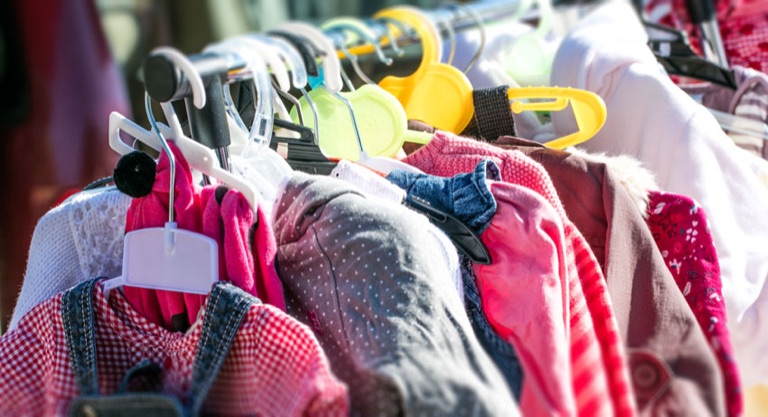 Kinderkleidung auf Bügeln an einer Kleiderstange
