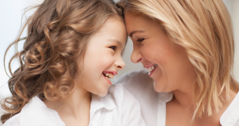 Mutter und Tochter Stirn an Stirn, beide lachen