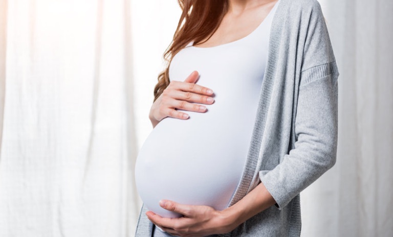Schwangere Frau hält ihren Bauch