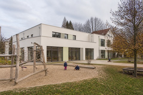 Kindertagesstätte von aussen, davor ein Sandspielplatz